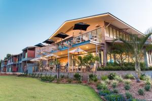 a large building with tables and umbrellas on it at Onslow Beach Resort in Onslow