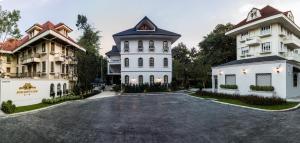 a driveway in front of three buildings at Merchant House Chiangmai in Chiang Mai