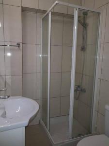 a shower with a glass door next to a sink at Marianna Hotel Apartments in Limassol