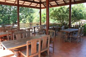 an outdoor restaurant with wooden tables and chairs at Waterside Resort in Pran Buri