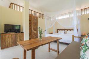 1 dormitorio con cama y mesa de madera en Le Forest Resort en Phu Quoc