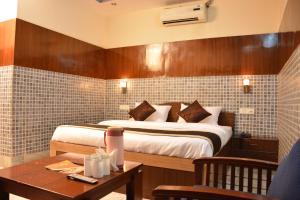um quarto de hotel com uma cama e uma mesa com uma mesa sidx sidx em Hotel Sartaj em Dera Bassi