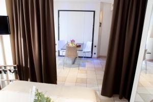 a view of a living room with curtains and a table at Hotel Villa d'Elsa in Juan-les-Pins
