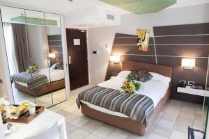 a hotel room with a bed and a mirror at Hotel Villa d'Elsa in Juan-les-Pins