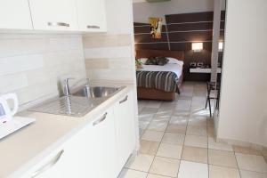 a kitchen with a sink and a bed in a room at Hotel Villa d'Elsa in Juan-les-Pins