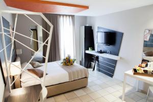 a hotel room with a bed and a tv at Hotel Villa d'Elsa in Juan-les-Pins