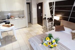 a room with a bed with a bouquet of flowers on it at Hotel Villa d'Elsa in Juan-les-Pins