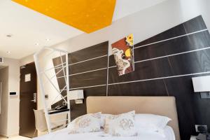a bedroom with a bed and a wooden wall at Hotel Villa d'Elsa in Juan-les-Pins