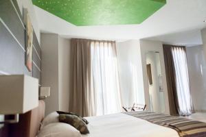 a bedroom with a bed and a green ceiling at Hotel Villa d'Elsa in Juan-les-Pins