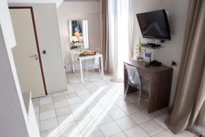 a living room with a television and a table with chairs at Hotel Villa d'Elsa in Juan-les-Pins