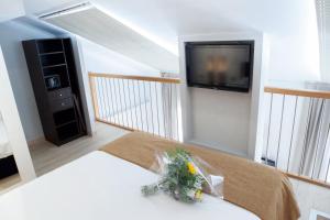 a bedroom with a bed with a tv on the wall at Hotel Villa d'Elsa in Juan-les-Pins