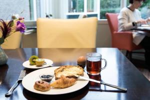 a table with a plate of bread and a glass of beer at Fletcher Hotel-Restaurant Mooi Veluwe in Putten