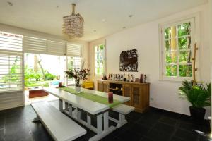 a kitchen with a table and benches and windows at Villa B52 in Punta Cana