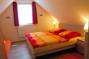 NeuhausにあるFerienwohnungen Dierhagen MOST 892のベッドルーム1室(ベッド1台付)、赤いカーテン付きの窓が備わります。