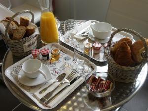 a table with two baskets of bread and a tray of food at Hostellerie Del Matin Calme in Montverdun