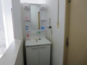 a white bathroom with a sink and a mirror at Minshuku Iwakawa in Yakushima +67 photos