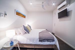 um quarto com uma cama com uma mesa e uma televisão em Onslow Beach Resort em Onslow