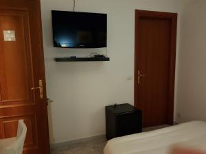 a bedroom with a bed and a television on a wall at La Dolce Vita Rome Ciampino in Ciampino