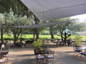 a group of tables and chairs under a white umbrella at Auberge d'Anais in Entrechaux