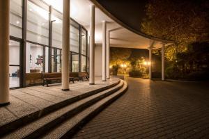 un edificio con una panchina di fronte ad esso di notte di FlyOn Hotel & Conference Center a Bologna