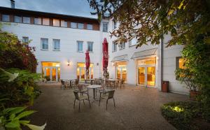 un patio con mesas y sillas frente a un edificio en EA Hotel Populus en Praga