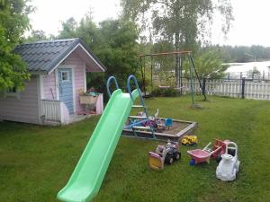 um parque infantil com escorrega e equipamento de brincar num quintal em Paratiisi Villat em Gäddnäs