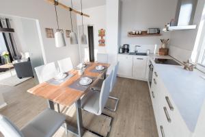 eine Küche und ein Esszimmer mit einem Holztisch und Stühlen in der Unterkunft Ferienwohnung MOSAIC in Eisenach