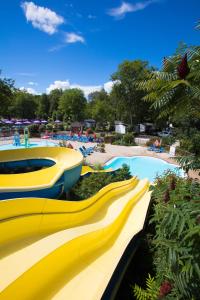 a yellow water slide at a water park at le Camping Des 3 Lacs in Belmont-Tramonet