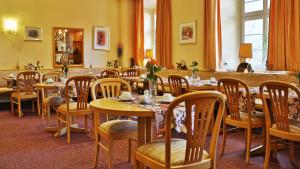 Hotel Am Schloss في آلتزي: غرفة طعام مليئة بالطاولات والكراسي