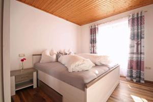a bedroom with a bed with white pillows and a window at Almliesl ZELL-448 in Zell am See