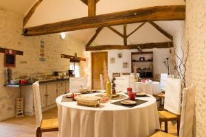 a kitchen with a table with a white table cloth at La Ferme de Vintué in Étréchy