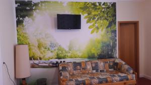 una sala de estar con sofá y una pintura en la pared en Hotel Restaurant Hellas, en Gelting