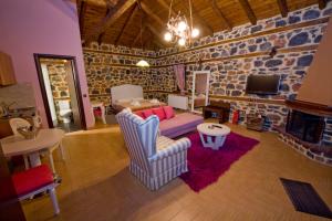 a living room with a couch and a fireplace at Xenonas Piperitsa in Palaios Agios Athanasios