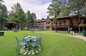 a table and chairs on a lawn in front of a building at Welcomhotel by ITC Hotels, Pine N Peak, Pahalgam in Pahalgām