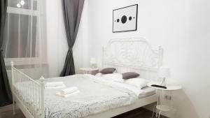 ein weißes Schlafzimmer mit einem weißen Bett und Kissen in der Unterkunft Apart City Center in Braşov