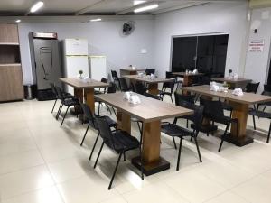 a classroom with tables and chairs and a chalk board at Lider Hotel in Jataí