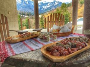 a table with two trays of food on it at Pensiunea Aurora Izvorul Muntelui in Bicaz