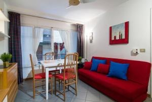フィレンツェにあるPonte Vecchio Florence Apartmentのリビングルーム(赤いソファ、テーブル付)