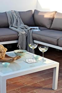 a white coffee table with wine glasses and a couch at Casa Opala Townhouse met Rooftop Pool in Olhão