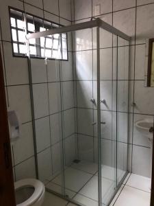 La salle de bains est pourvue d'une douche en verre et de toilettes. dans l'établissement Lider Hotel, à Jataí