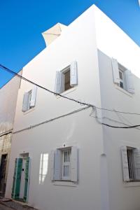 a white building with four windows on it at Casa Opala Townhouse met Rooftop Pool in Olhão +44 photos