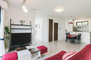 een woonkamer met een bank, een tv en een tafel bij United Resort Sarabeth in Onna
