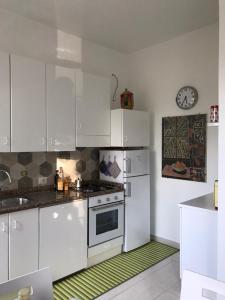 a kitchen with white appliances and a clock on the wall at La Riva Sinistra in Rome