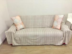 ein Sofa mit zwei Kissen auf einem Zimmer in der Unterkunft Residenza Sant Orsola Azzurra Mazzini self check in in Bologna