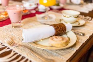 a table with a plate of food with a roll on it at Vivere Ad Parcum - Bed And Breakfast in Krefeld