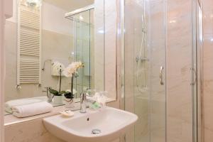 Un baño blanco con lavabo y ducha. en Antico Mercato, en Venecia 37 fotos más