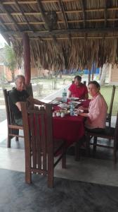 grupa ludzi siedzących przy stole w obiekcie airport eco cottage w mieście Katunayake
