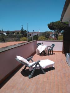 patio con 2 sedie e tavolo sul tetto di B&B Villa Giovanni a Casal Palocco