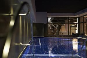 a swimming pool with blue tiles in a building at Steel House Copenhagen in Copenhagen