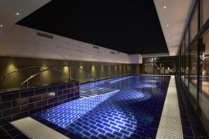 a swimming pool with blue tiles in a building at Steel House Copenhagen in Copenhagen